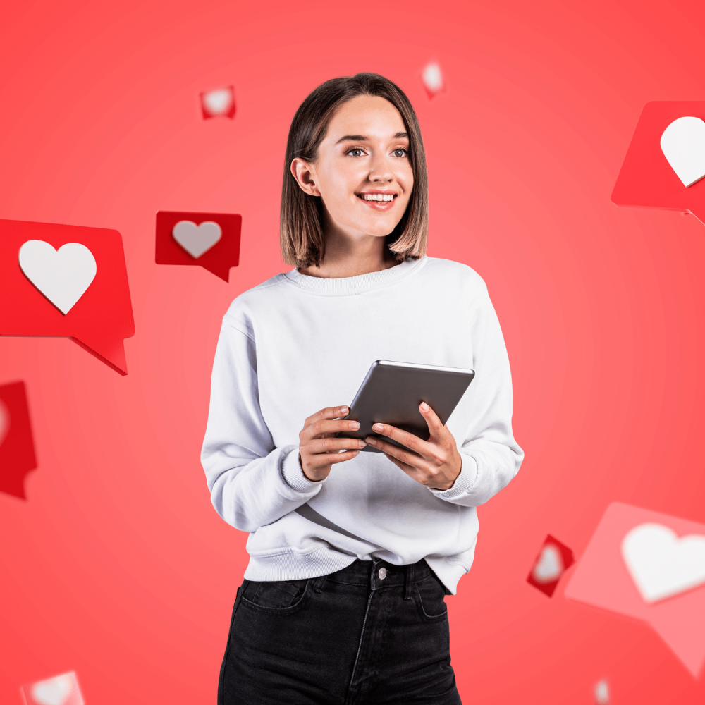 Frau mit Tablet vor rotem Hintergrund mit fliegenden Social Herz Icons